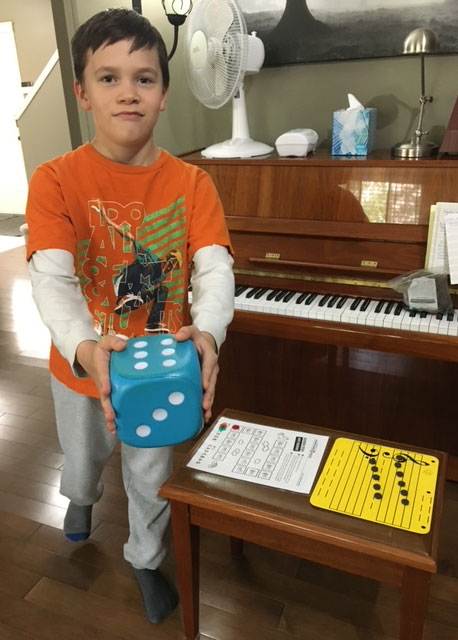 Boy learning to play the piano using teaching game