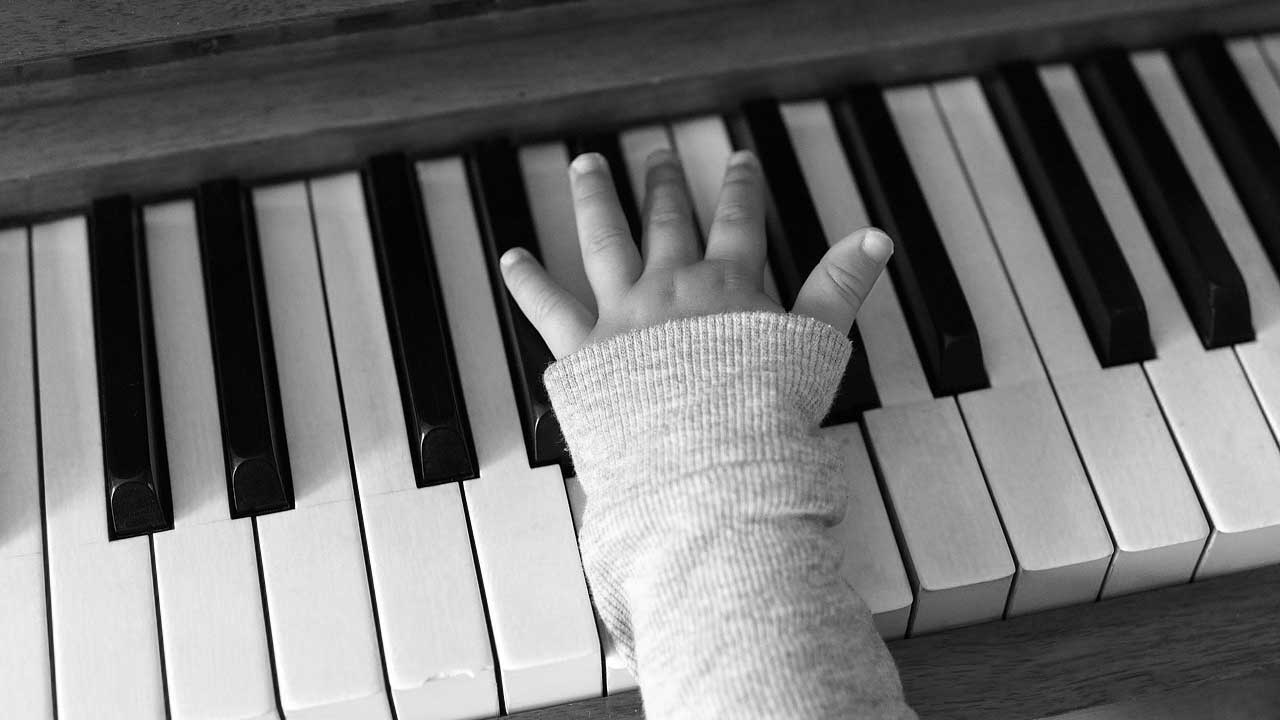 Young childs hands playing the keys on the piano
