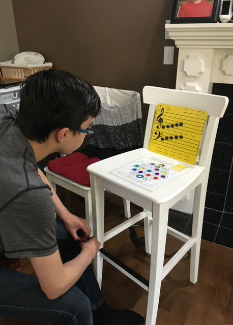 Boy learning to play the piano using teaching game